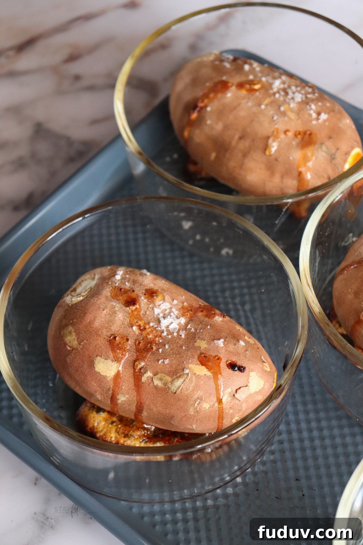 Baked Sweet Potato Bowls showing cooked sweet potato in glass meal prep bowl.