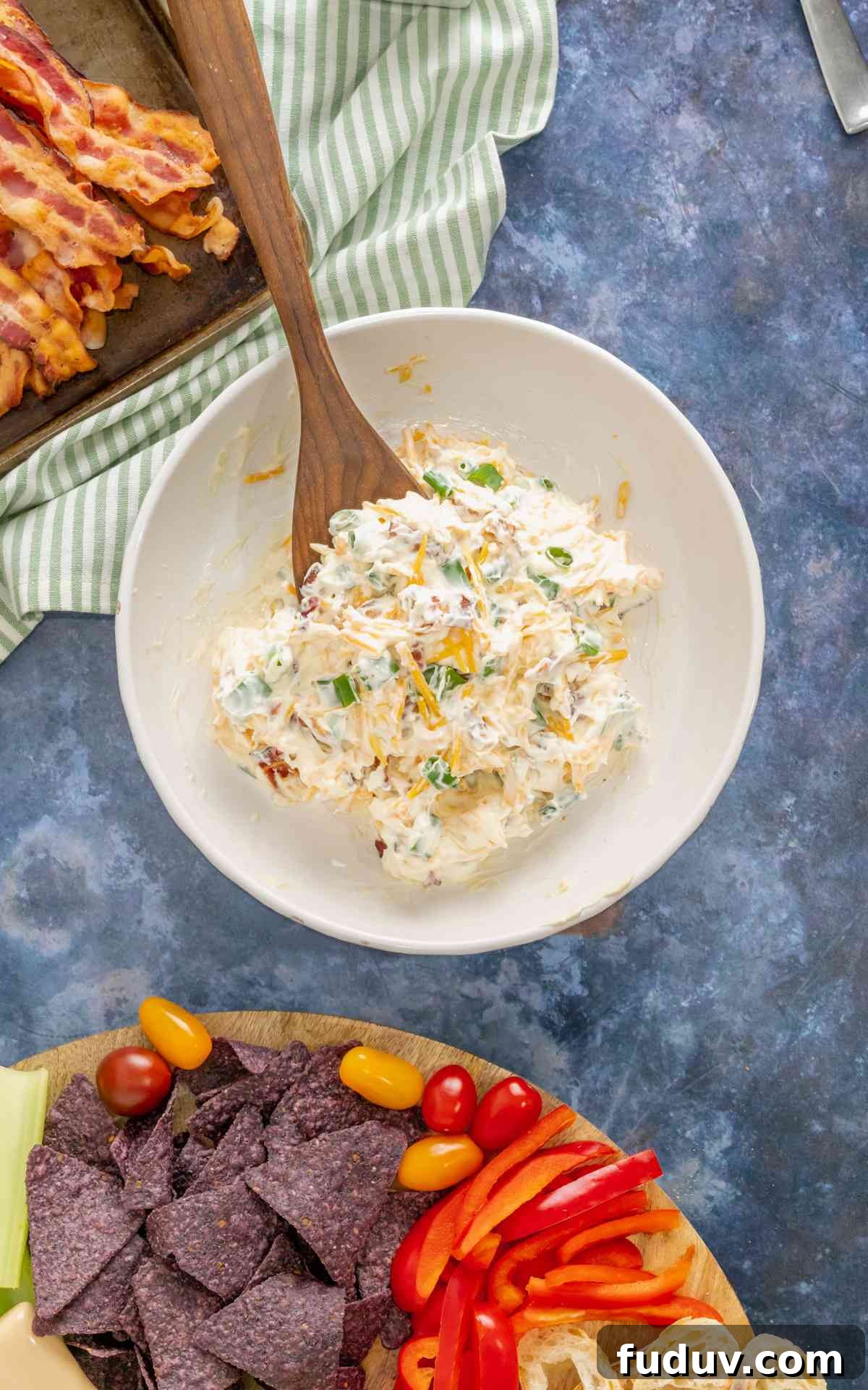 Million-Dollar Dip Recipe: Luxurious Party Appetizer with Truffle and Lobster 4 Beginning process shot of 5 minute million dollar dip being made in a bowl with a wooden spoon.