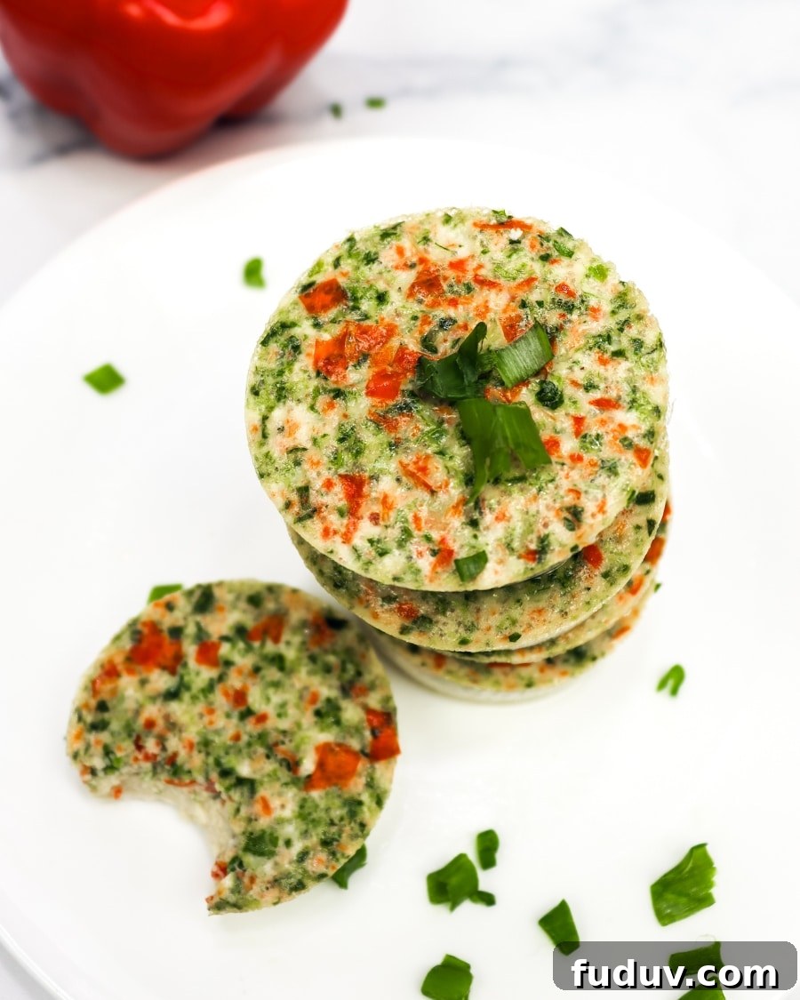 25 High-Protein, Low-Carb Breakfast Recipes to Start Your Day 4 keto egg bites on a white plate with a bell pepper in the background, one bite taken out of one egg bite