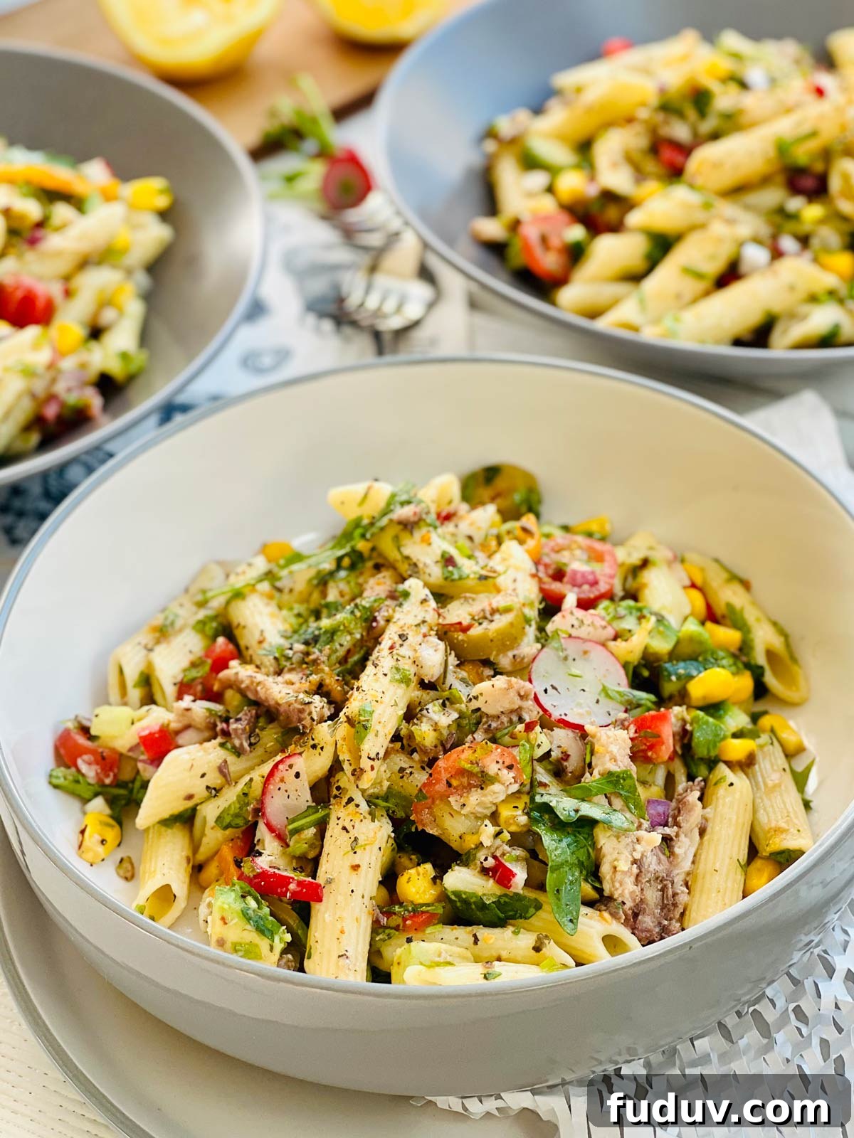 A closeup of a bowl containing spanish sardines pasta penne with sweet corn, radish black pepper and herbs