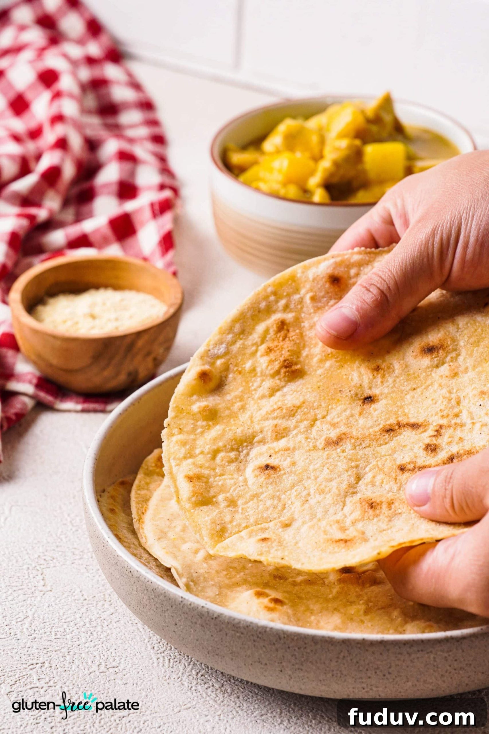 Gluten-free roti being taken out of a bowl