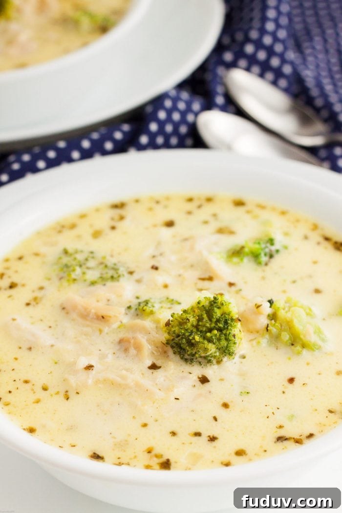 closeup of a bowl of keto soup in a white bowl next to spoons