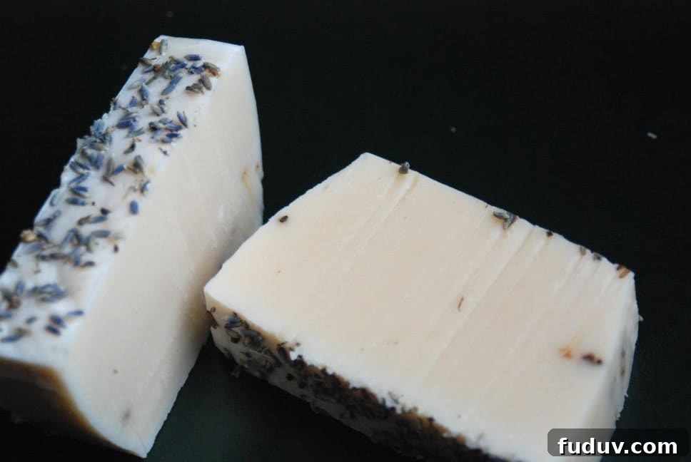 Top Essential Oil Blend Recipes for Soap Making 5 Image shows two bars of lavender peppermint soap laying in different directions on a black surface