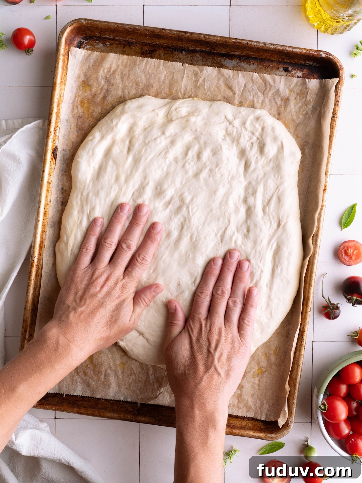 Hands gently pressing and stretching bread dough