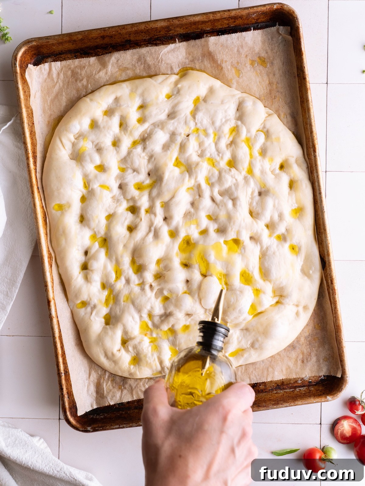 Drizzling basil flower oil onto sourdough focaccia before baking