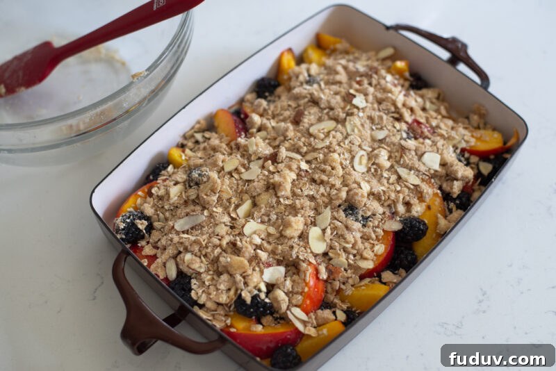 Nectarine blackberry crisp in a baking pan is ready to bake in the oven.