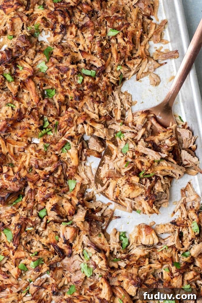A baking pan showing the crispy texture of carnitas after bring broiled.