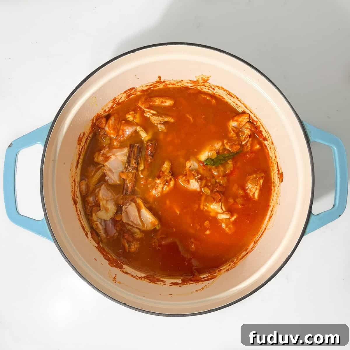 Adding water to the pot of curry.