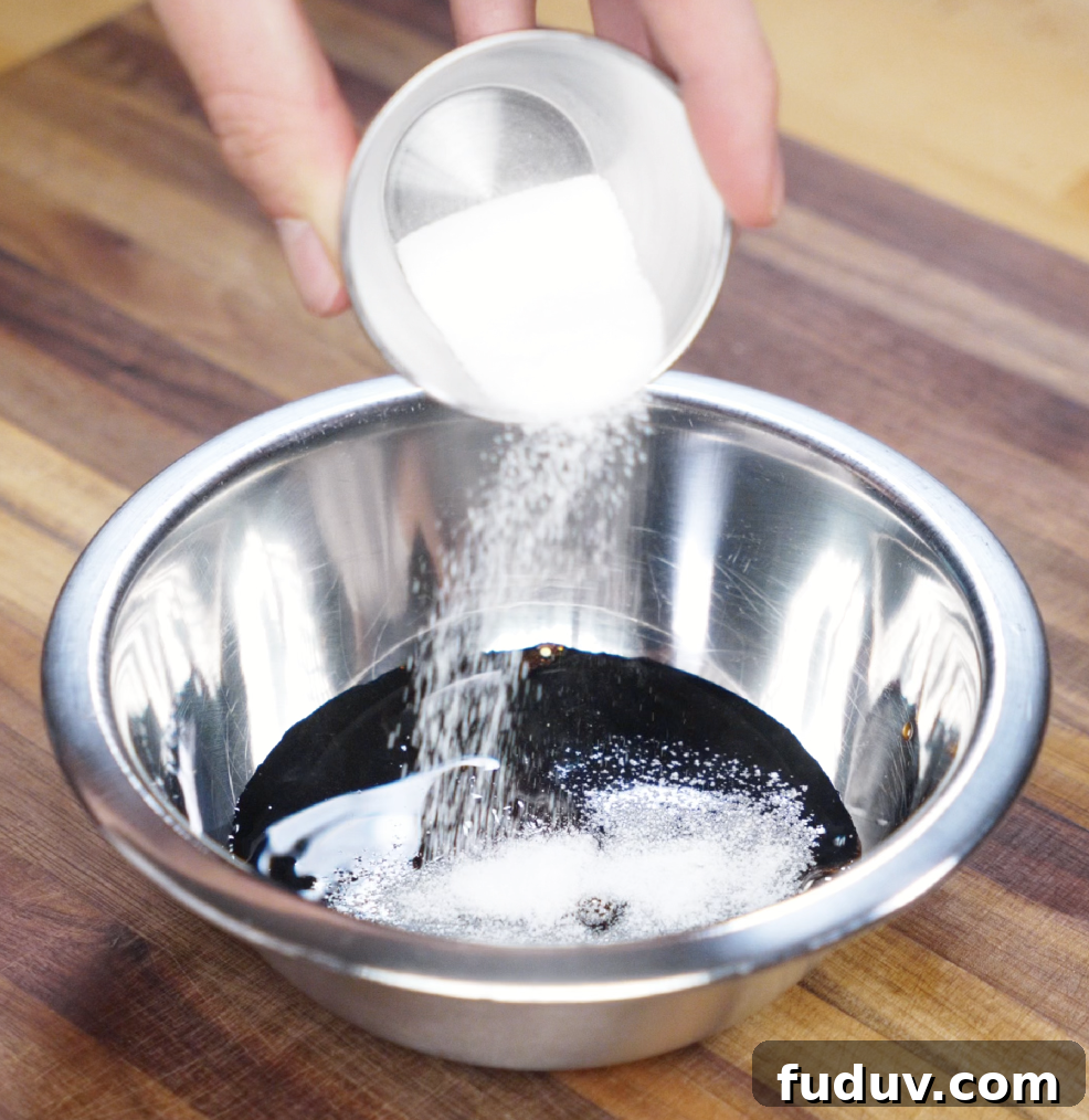 Crispy Chicken Pan-Fried Noodles with Savory Stir-Fry Sauce 4 Granulated sugar is being poured into a metal bowl filled with soy sauces and oyster sauce. This simple sauce blend brings deep umami and subtle sweetness to the noodles.