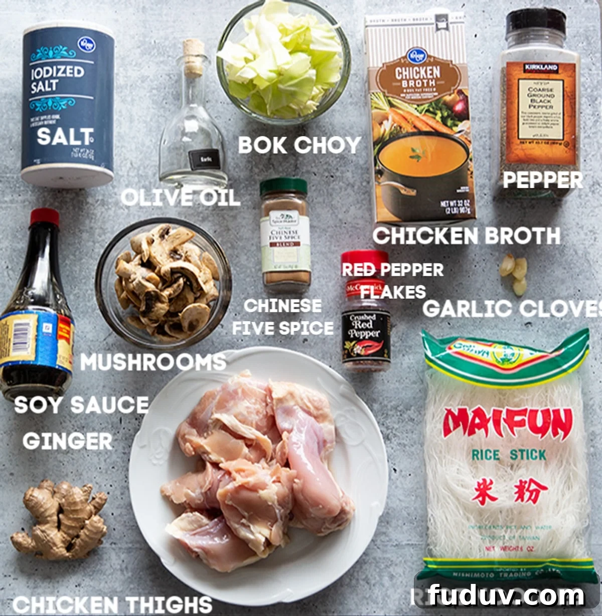 Chicken thighs, rice noodles, ginger, soy sauce, salt, olive oil, bok choy, chinese five spice, chicken broth and garlic on counter.