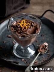 Vegan chocolate orange pot on a metal tray with a spoonful removed.
