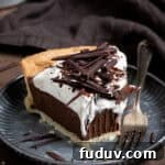 A slice of vegan chocolate cream pie on a metal plate with a forkful removed.