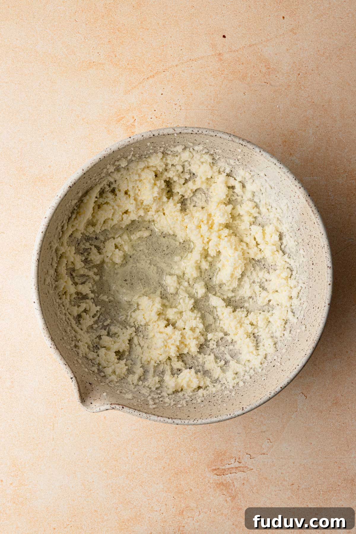 A large bowl with cream butter and sugar.