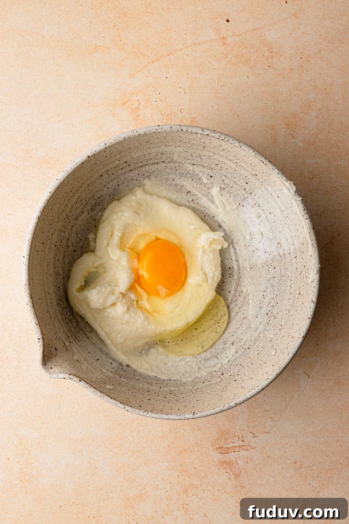 A large bowl with cream butter and sugar and an egg.