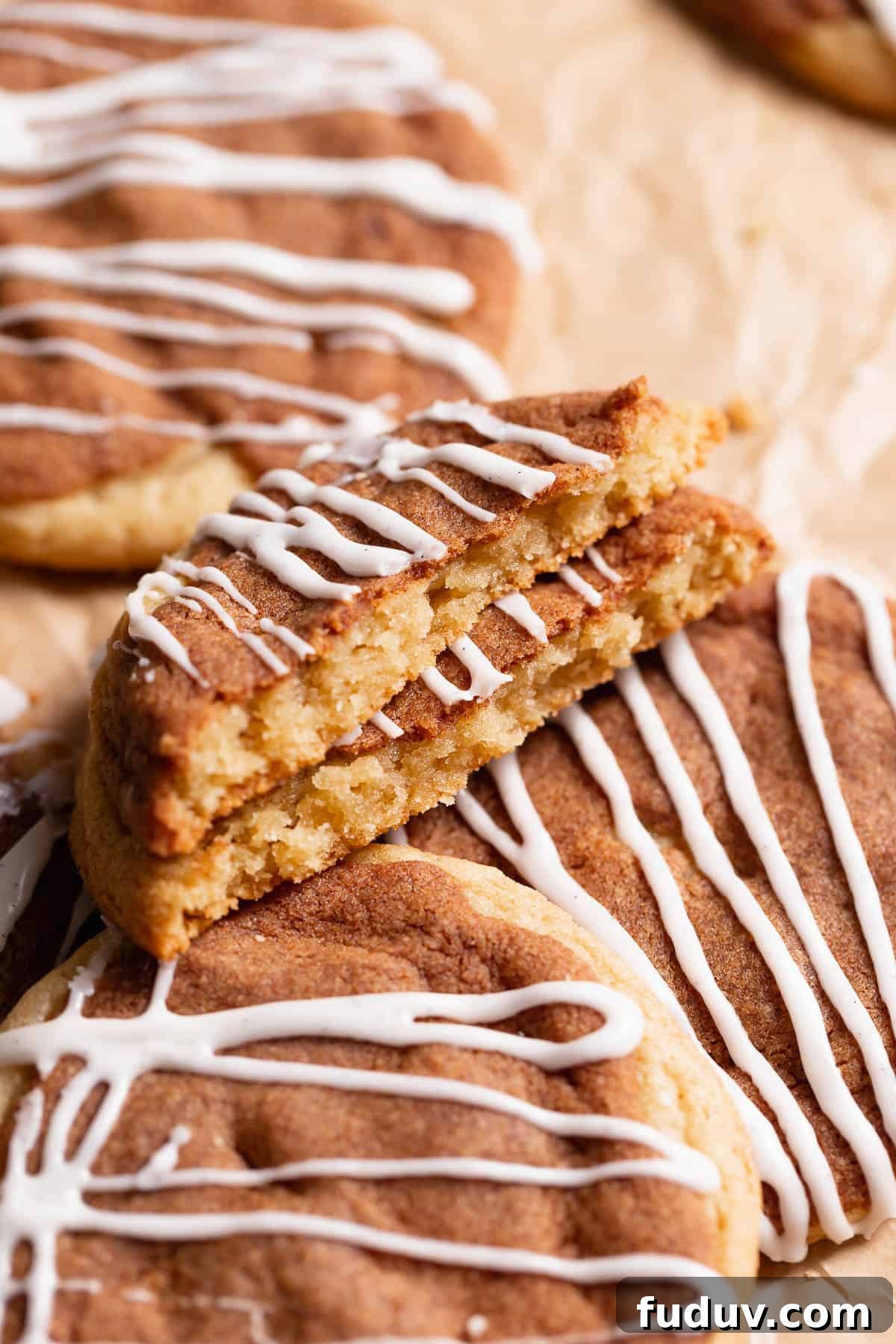 Cinnamon bun cookie broken in half to show the cinnamon sugar layer.