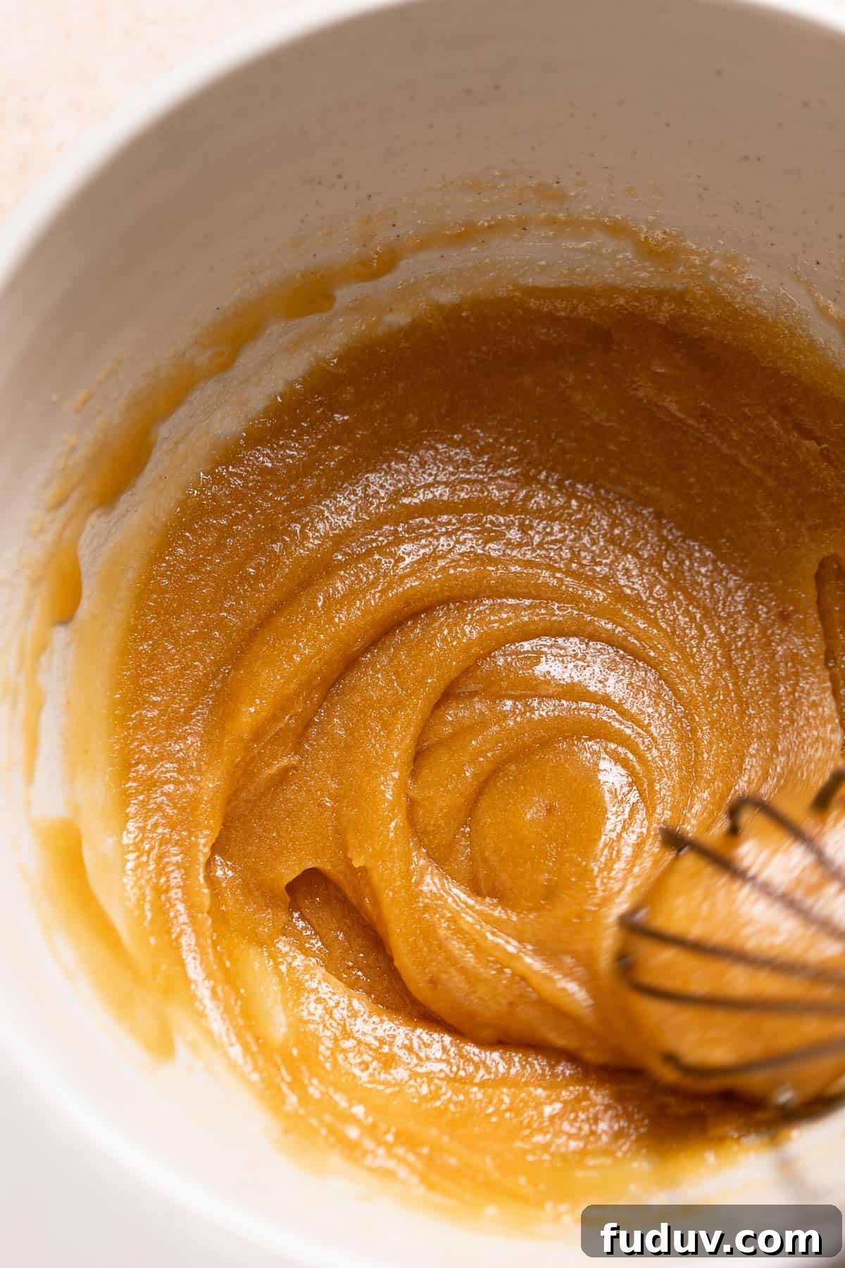 A mixing bowl with the whisked melted butter and sugars.