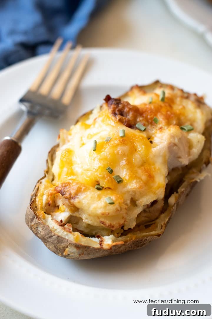 Air Fryer Twice-Baked Potatoes with Chicken and Crispy Bacon 8 a loaded twice baked potato on a plate with a fork