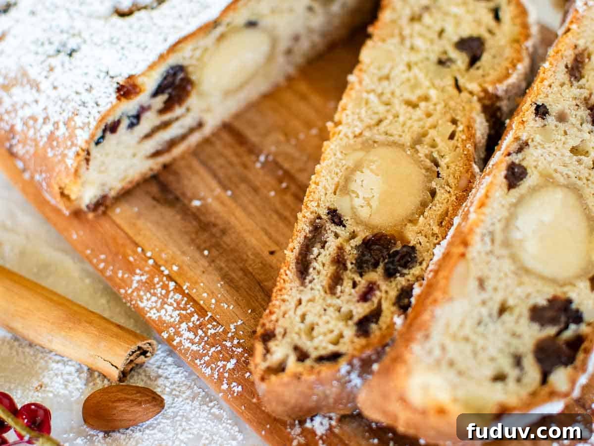 Traditional German Stollen Recipe: Classic Holiday Fruit Bread 11 Close up of slices of bread studded with dried fruit.