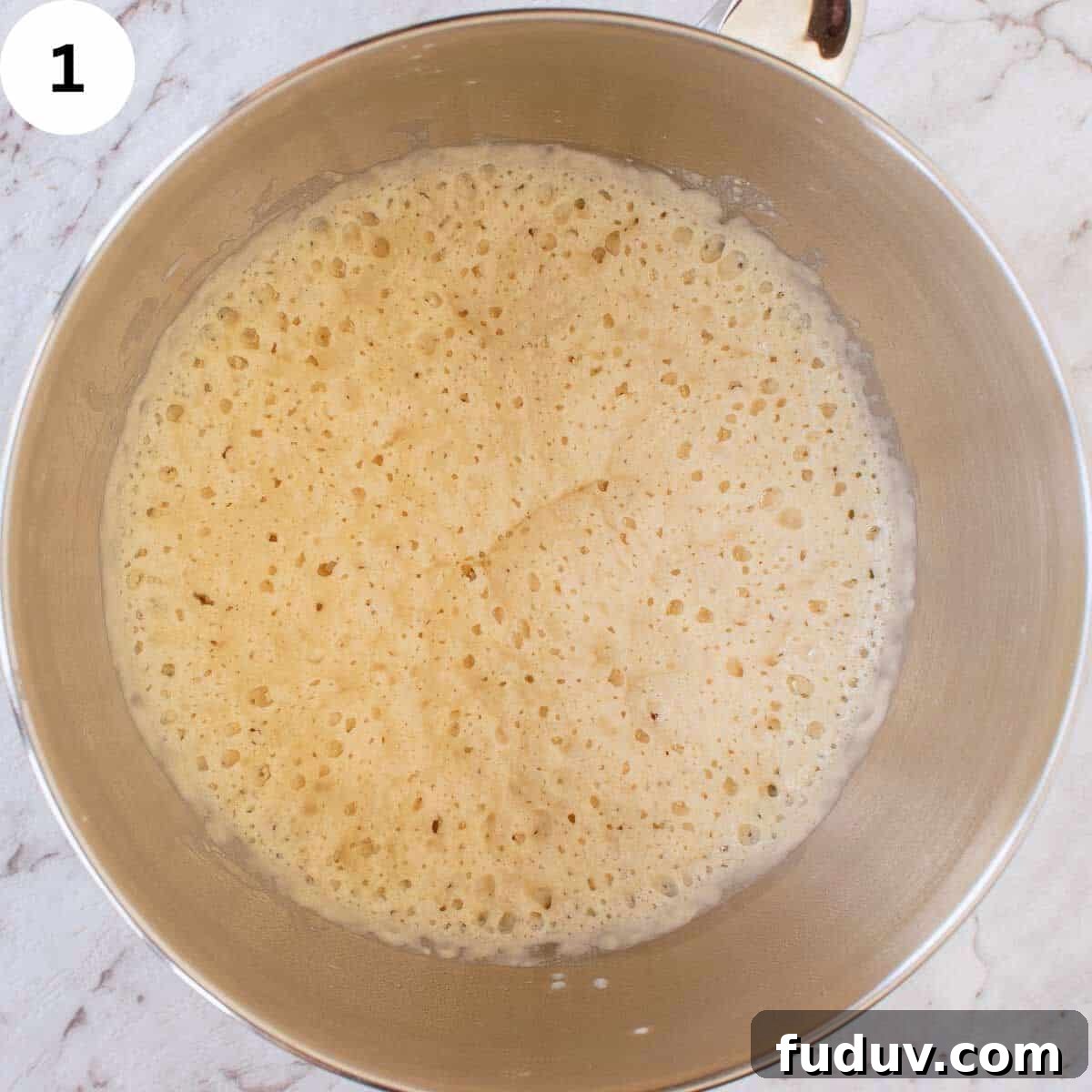 Traditional German Stollen Recipe: Classic Holiday Fruit Bread 4 Pale yellow, bubbly batter in a stainless steel bowl.