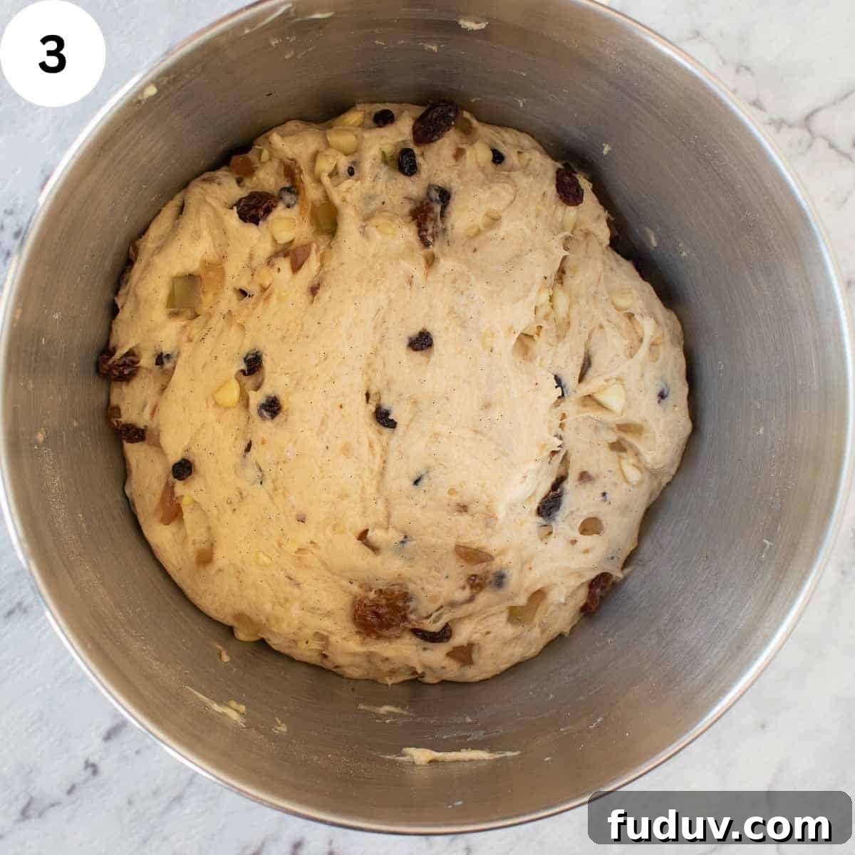 Traditional German Stollen Recipe: Classic Holiday Fruit Bread 6 Ball of dough with dried fruit through it in a stainless steel bowl.