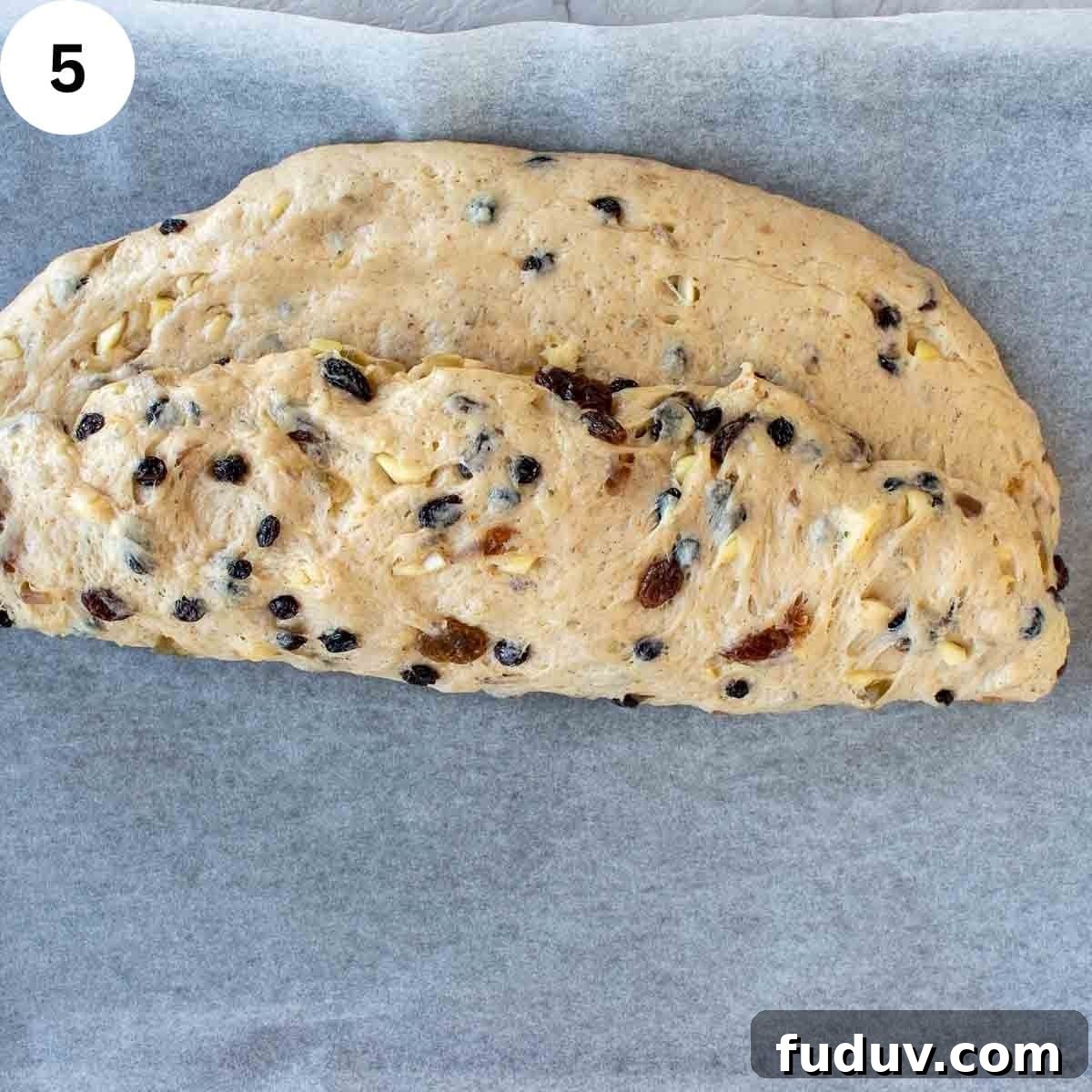 Traditional German Stollen Recipe: Classic Holiday Fruit Bread 8 Dough with dried fruit through it folded over into a semicircle.