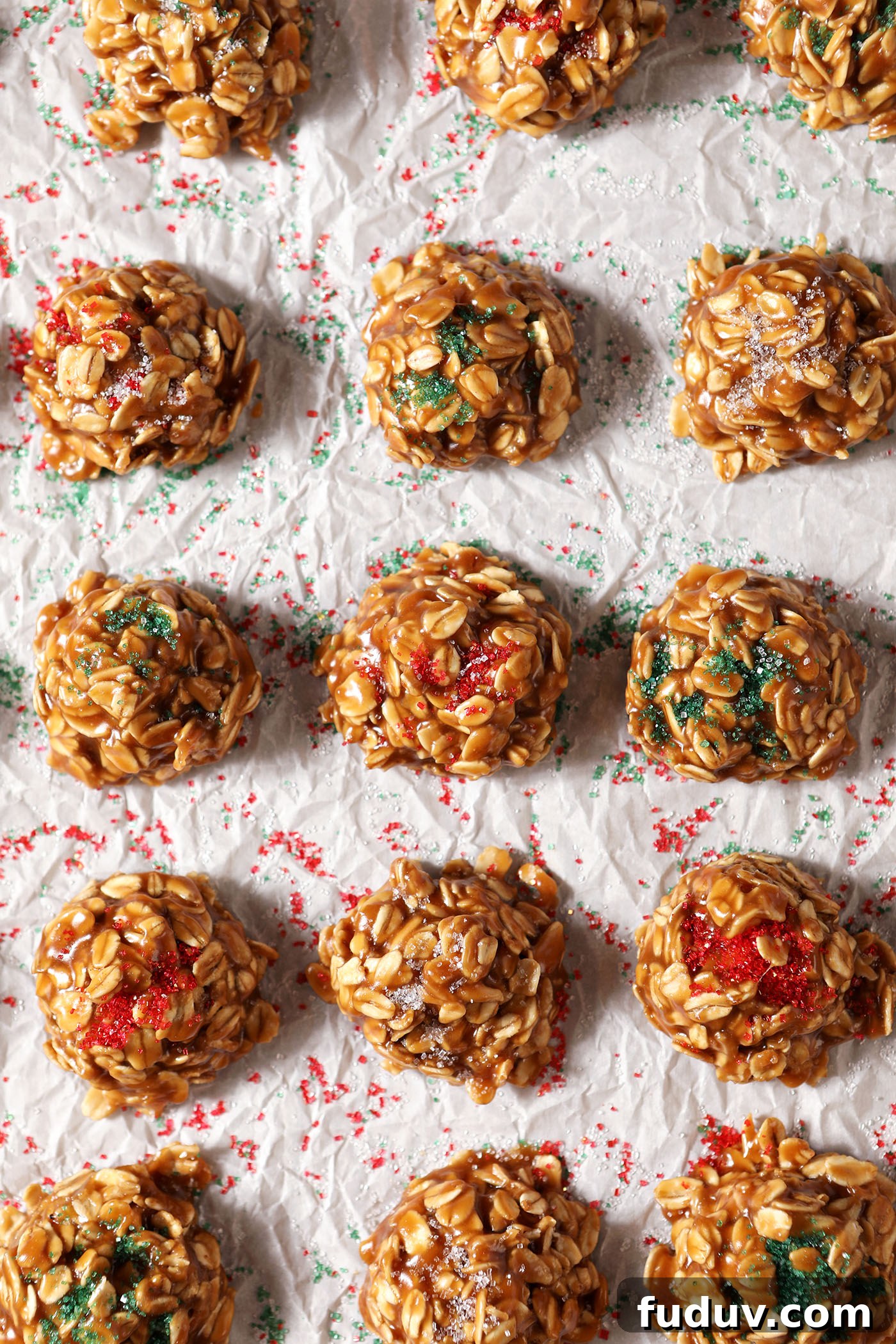 No bake cookie butter cookies decorated with Christmas colored sugars on a parchment-lined sheet pan