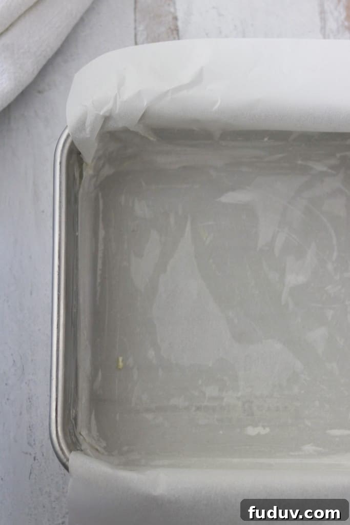 A pan lined with parchment paper on a wooden surface