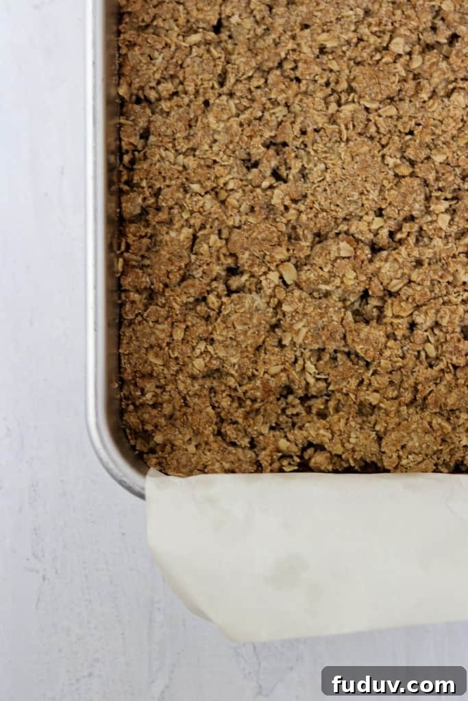 Baked crumble bars in a pan on a wood surface