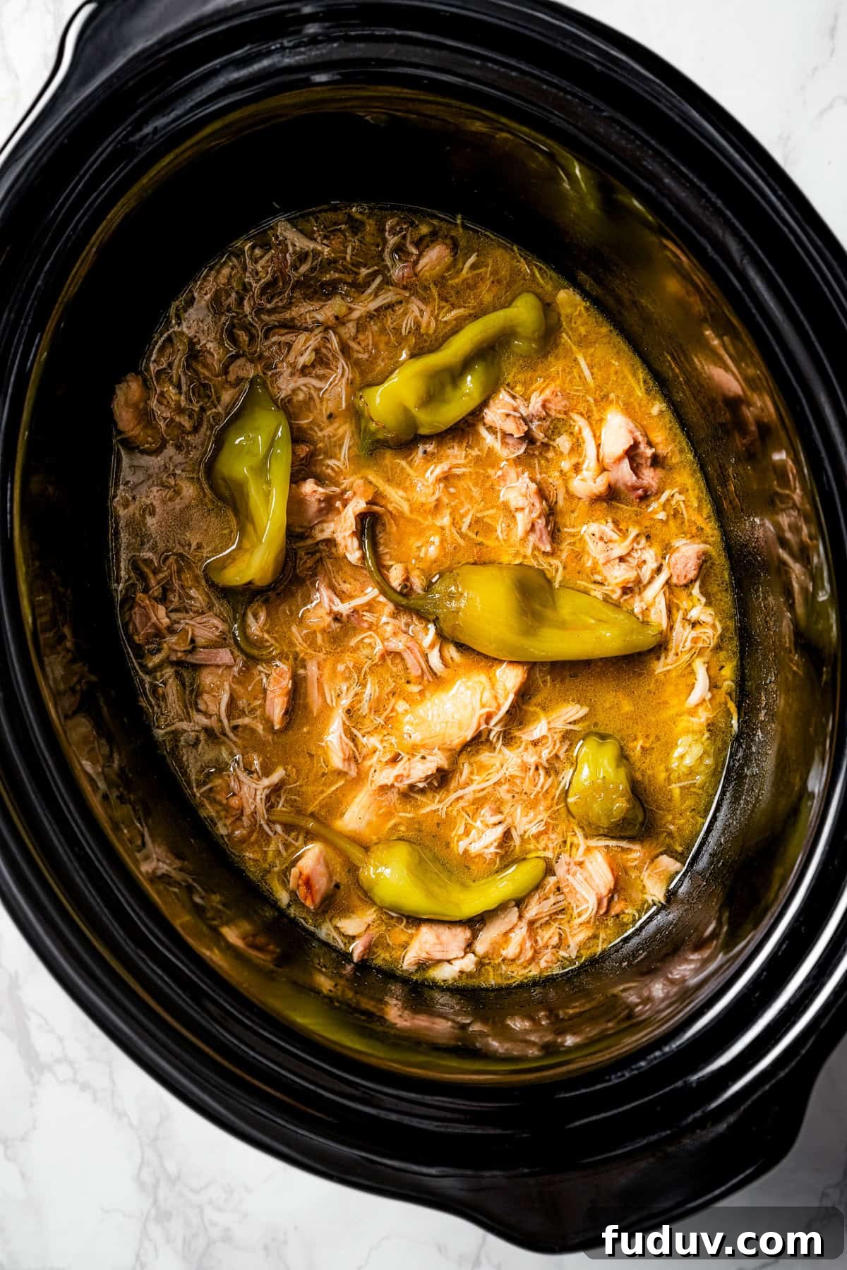 Mississippi chicken is an easy crock pot recipe with juicy chicken shredded in savory pepperoncini ranch sauce. Make it with 5 ingredients! Overhead view of Mississippi chicken inside the slow cooker.