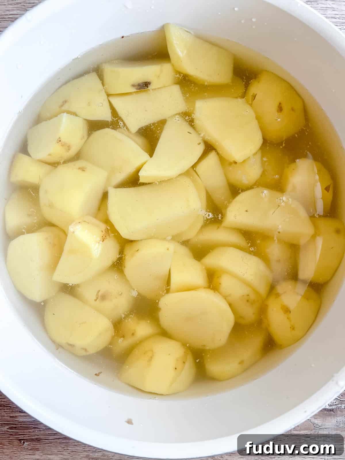 Potatoes in a large pot of hot water.