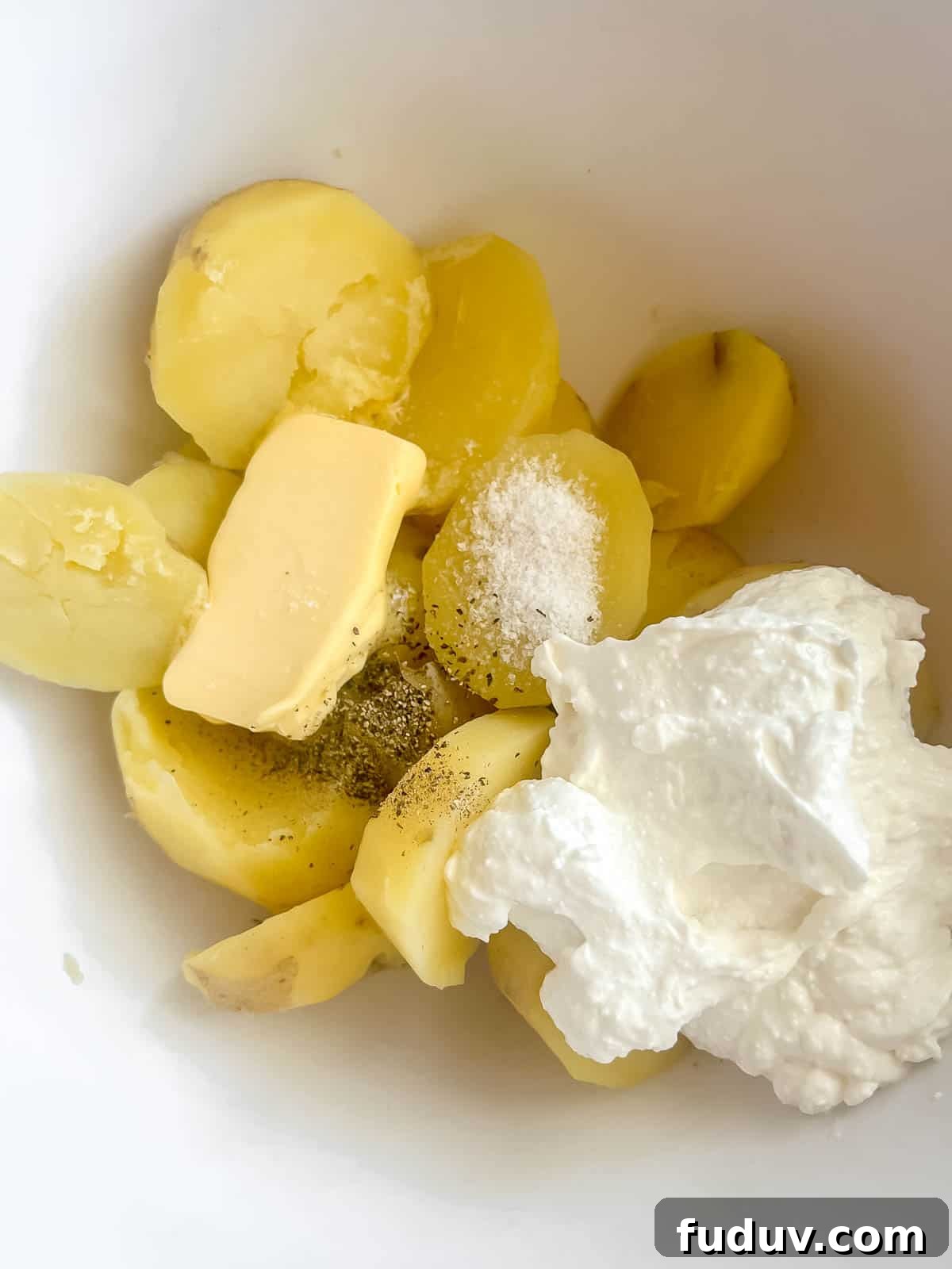 The potatoes, cottage cheese, butter, salt and pepper in a large bowl.