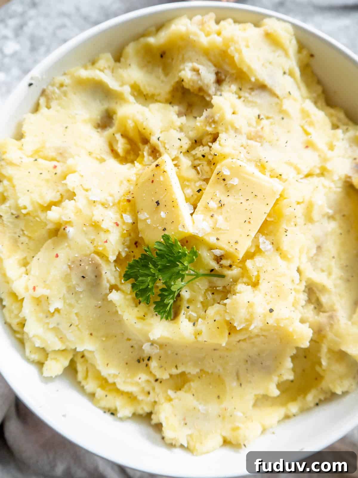 Cottage cheese mashed potatoes in a bowl with butter on top.