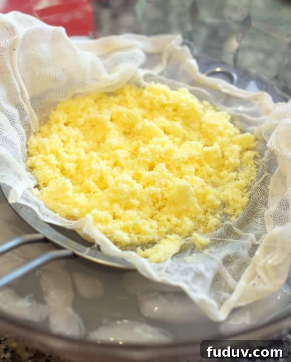 Rinsing the butter solids in a strainer for homemade butter.