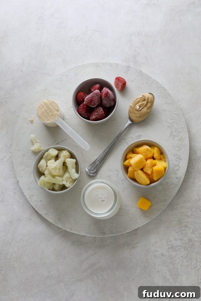 Strawberry Mango Smoothie Bowl ingredients on white board