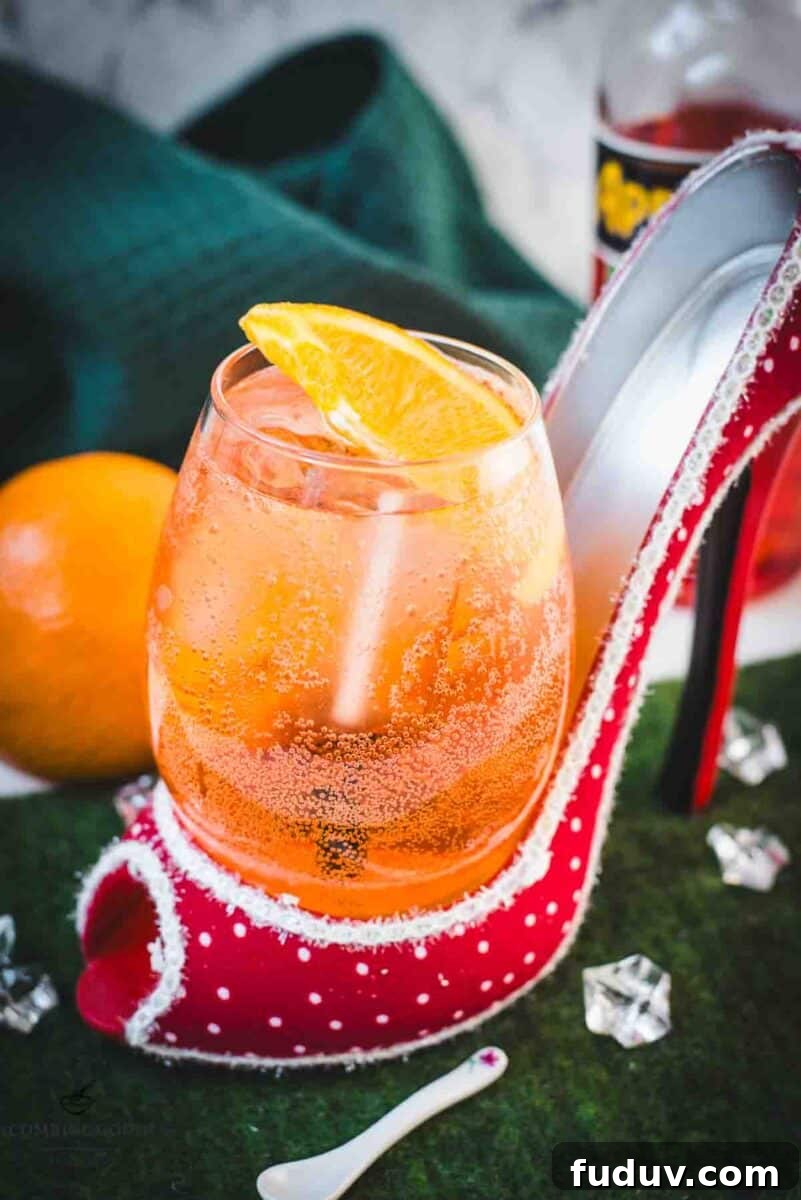 Aperol Spritz Made with Wine: How to Swap Prosecco for Table Wine 2 Aperol spritz with white wine instead of prosecco playfully served in a red and white polka dot high heel. Garnished with n orange slice.