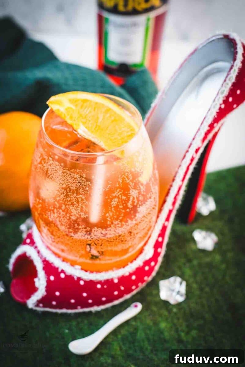 Aperol Spritz Made with Wine: How to Swap Prosecco for Table Wine 3 Aperol spritz with white wine instead of prosecco playfully served in a red and white polka dot high heel. Garnished with n orange slice.
