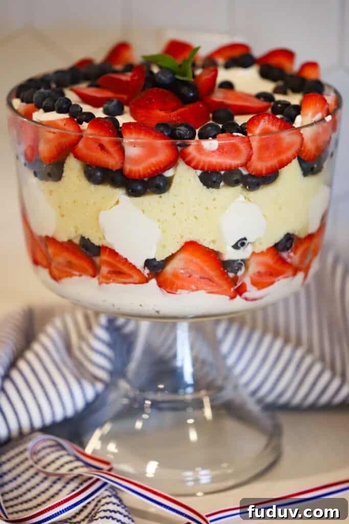 berry trifle recipe in a large trifle dish decorated with star shaped pound cake, strawberries and blueberries.