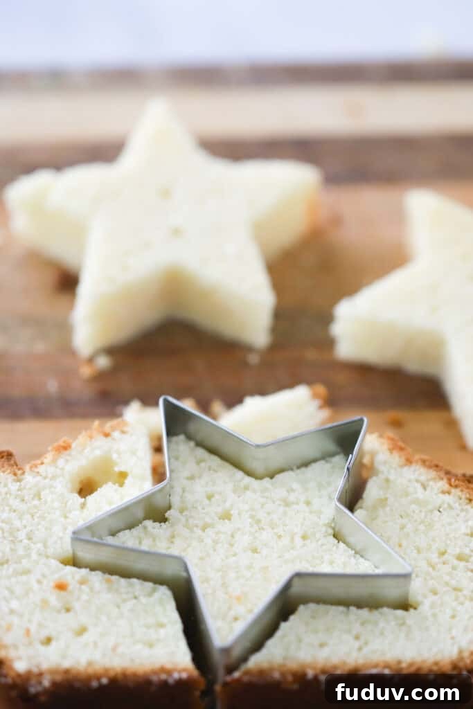 Pound cake on a cutting board cut into star shapes using a cookie cutter.