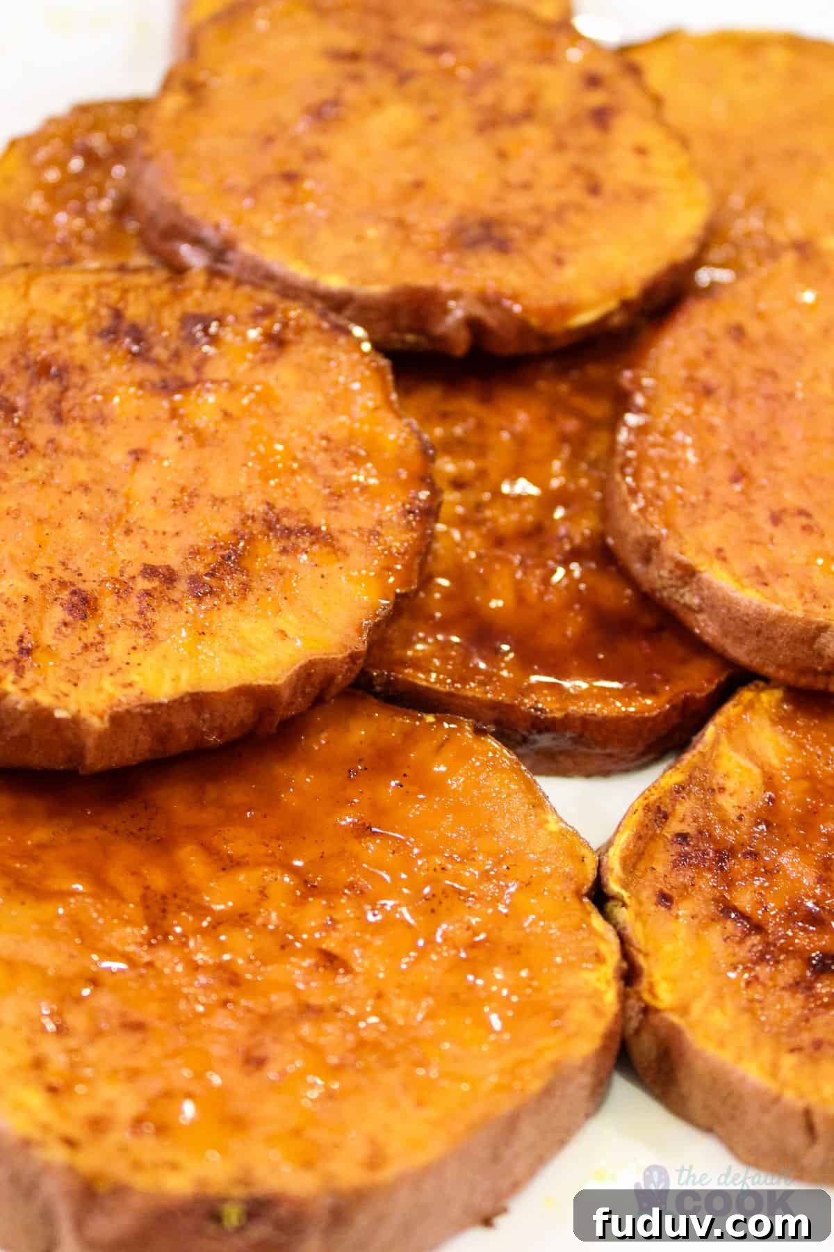 Close up of roasted sweet potato rounds on a white plate.
