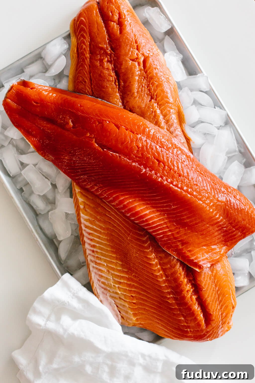Raw salmon filets on a tray of ice.
