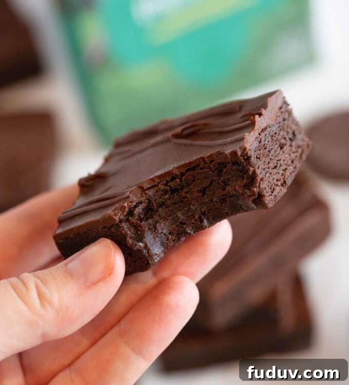 Thin Mint Cookie Bars Recipe with Chocolate Ganache 3 hand holding thin mint cookie bar square with bite