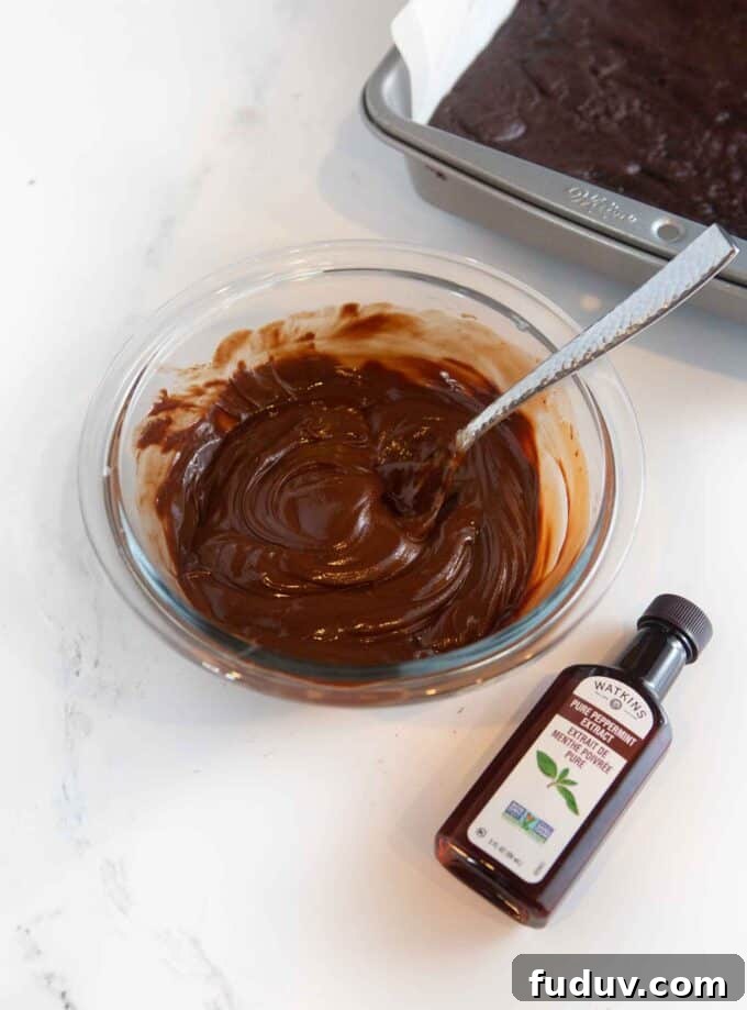 Thin Mint Cookie Bars Recipe with Chocolate Ganache 9 glass bowl of melted chocolate chips with peppermint extract bottle off to the side