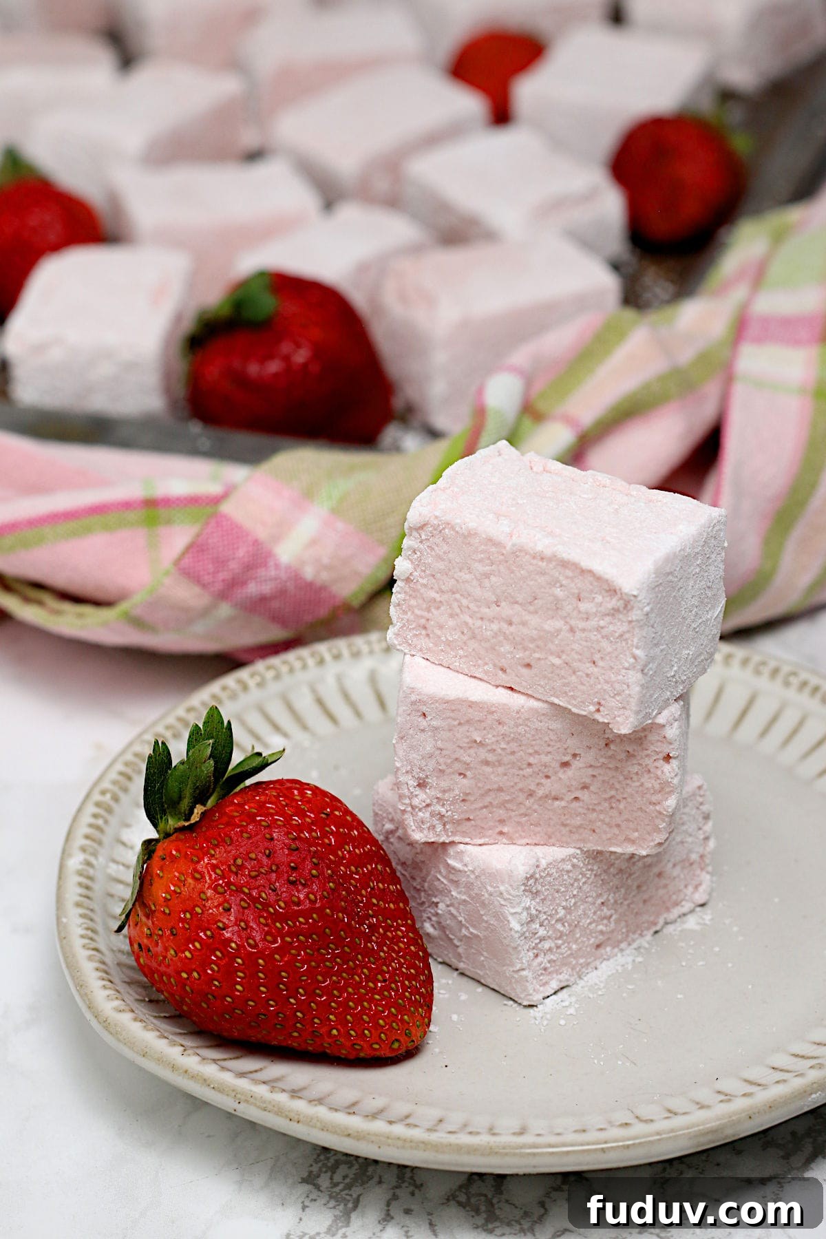 A stack of three Homemade Strawberry Marshmallows on a small white plate.