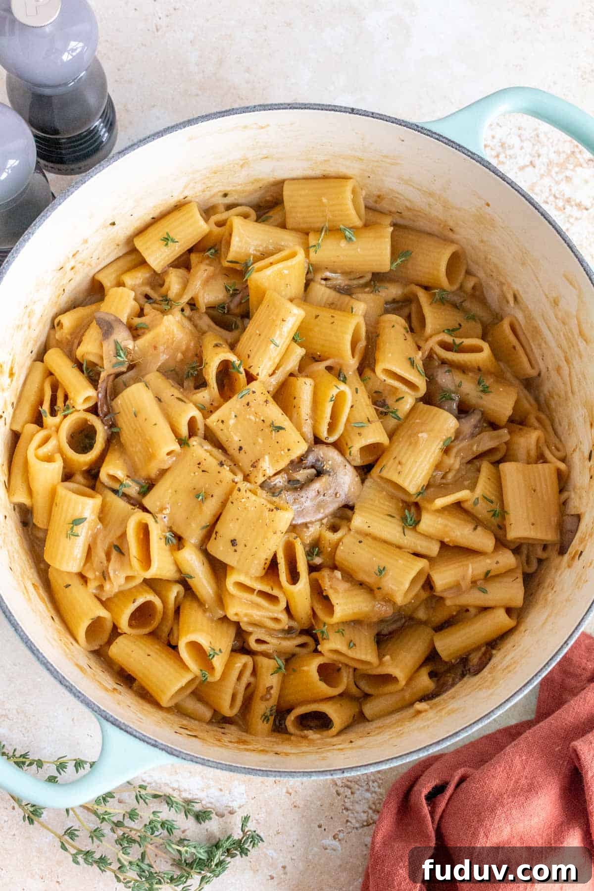 Overhead view of an one pot french onion pasta topped with fresh thyme as garnish.