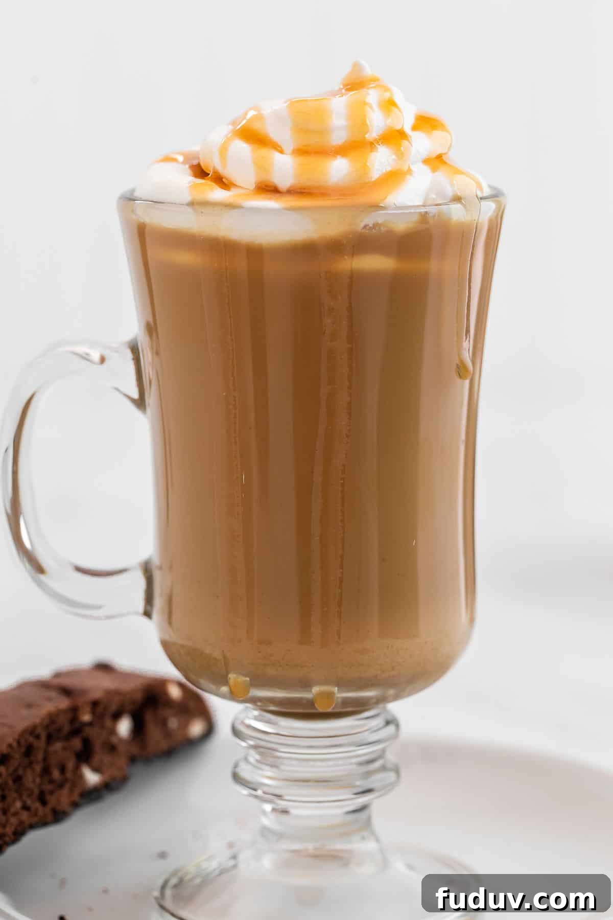 How to Make a Rich Caramel Latte at Home in Minutes 7 Close up of caramel latte in clear glass garnished with whipped cream and caramel.
