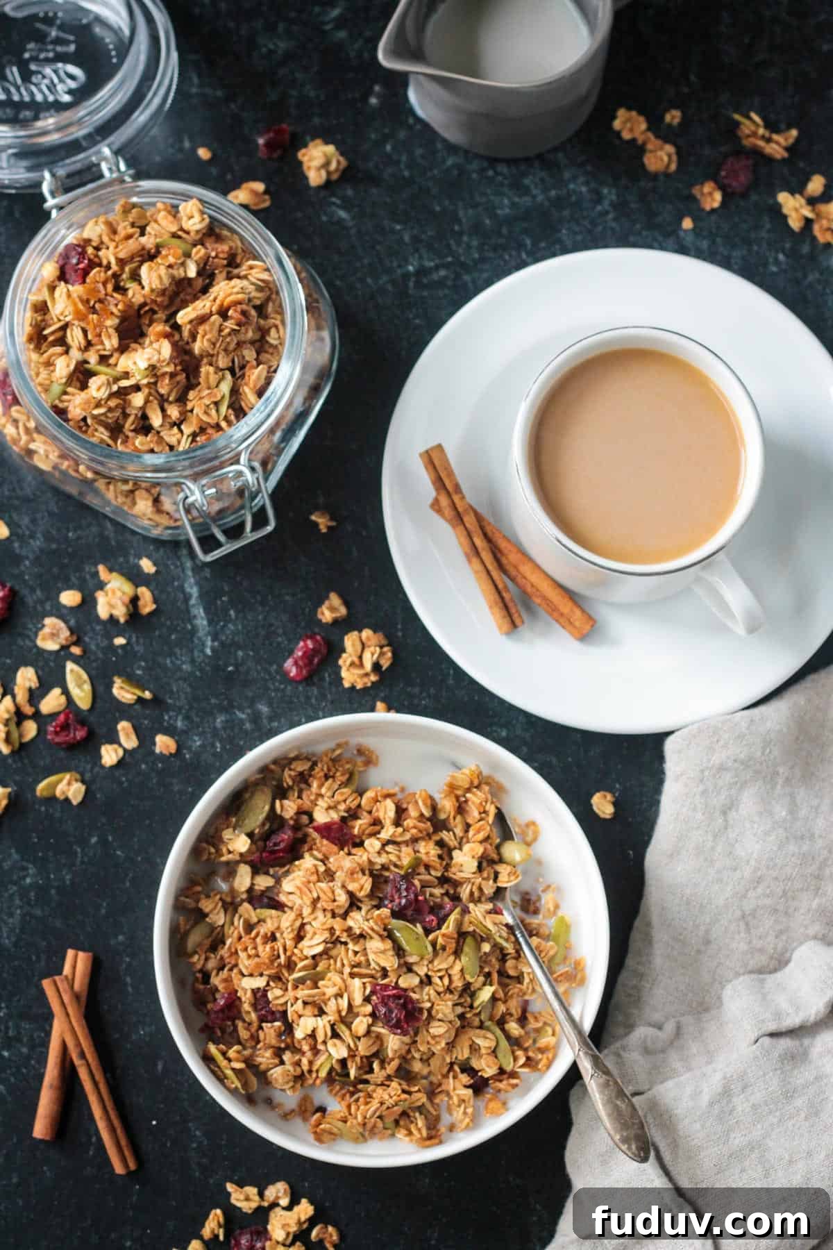 Vegan Pumpkin Spice Granola Recipe for Fall Breakfasts 14 Bowl of granola next to a cup of coffee and a jar of more granola.