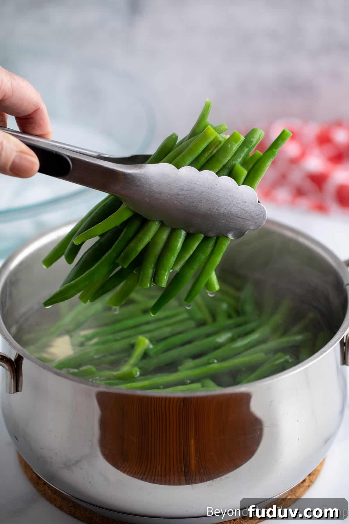 Removing green beans from boiling water.