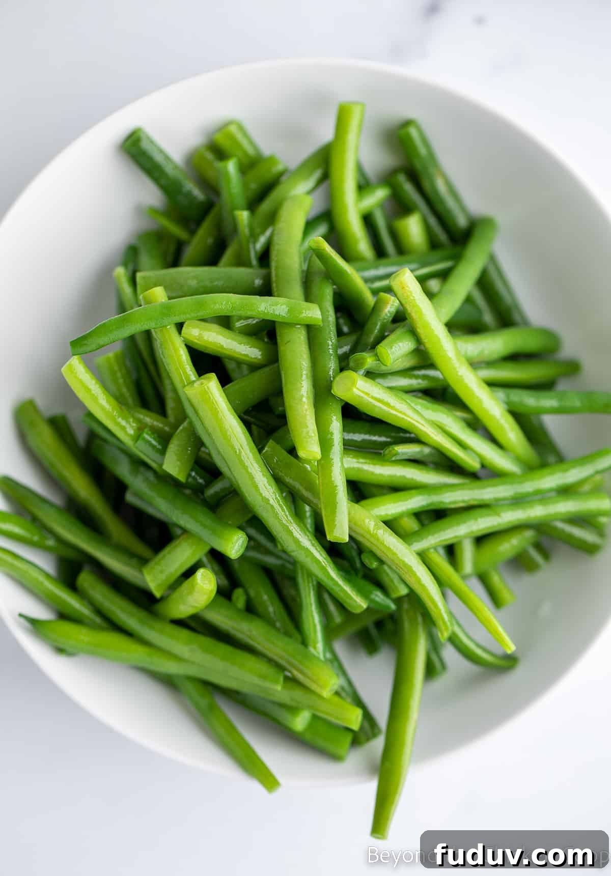 Green beans in a white bowl. 