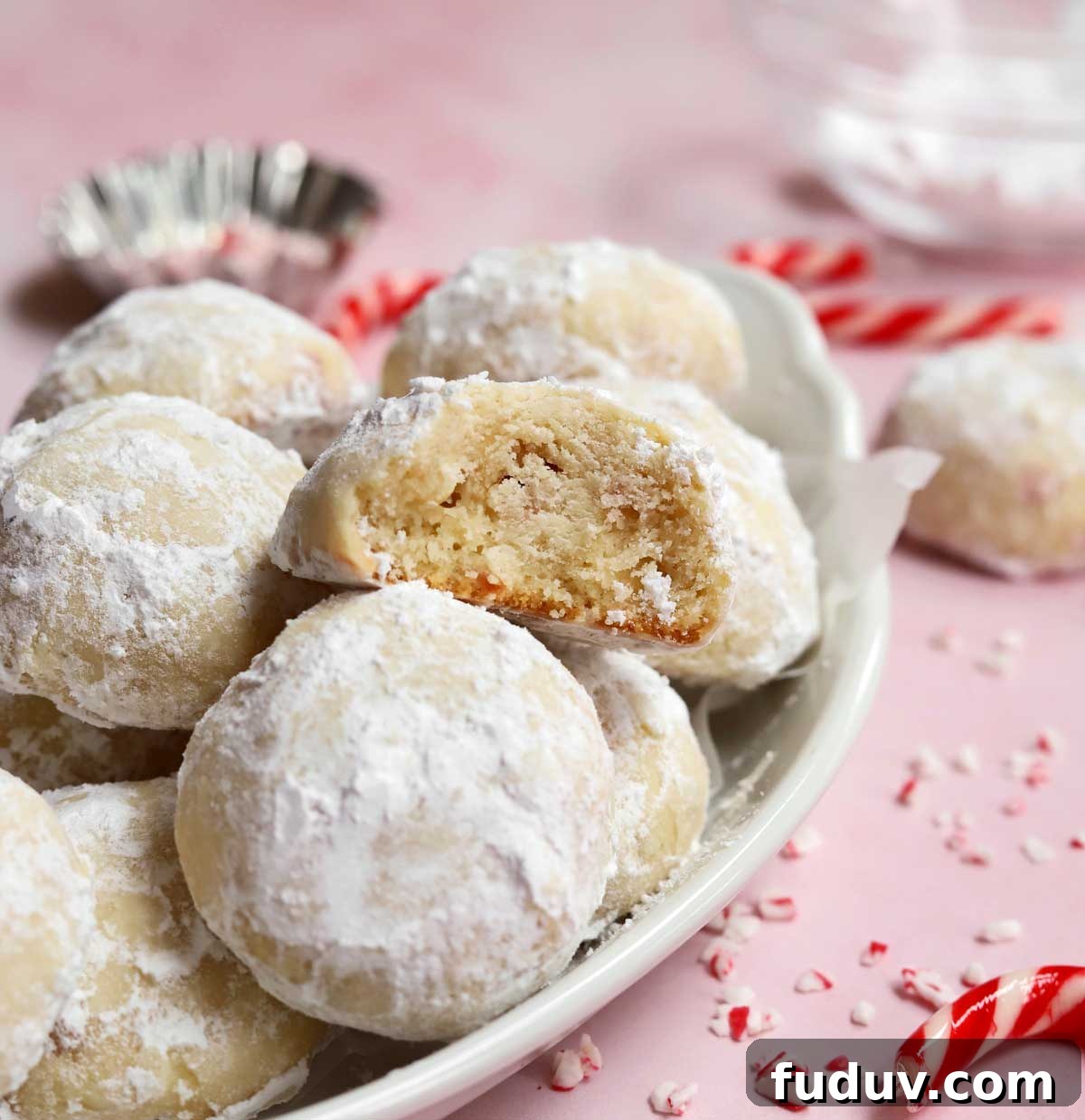 peppermint snowball cookies in a serving dish with bite showing tender insides