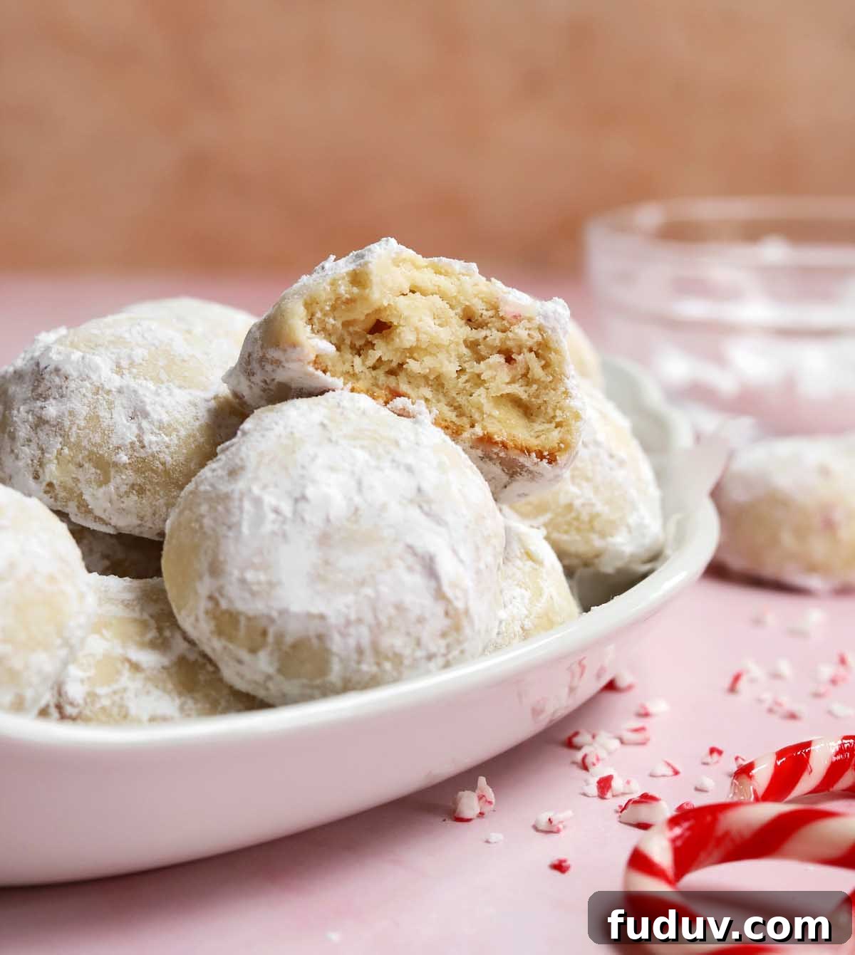 peppermint snowball cookies in a serving dish with bite showing tender insides